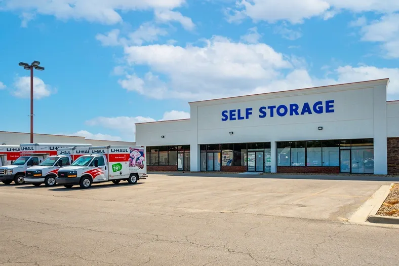Self storage facility storefront with U-Haul trucks parked outside for moving and rental services