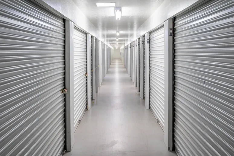 Climate-controlled indoor storage hallway with secure roll-up unit doors
