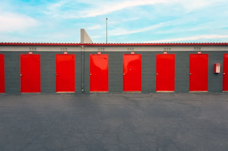 Drive-up storage units with red roll-up doors and secure access