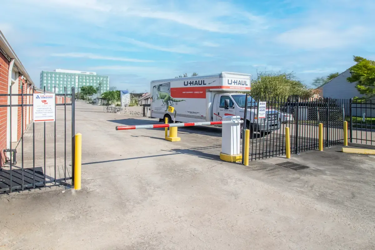 Secure gated entrance at Devon Self Storage with keypad access and U-Haul truck parked inside facility