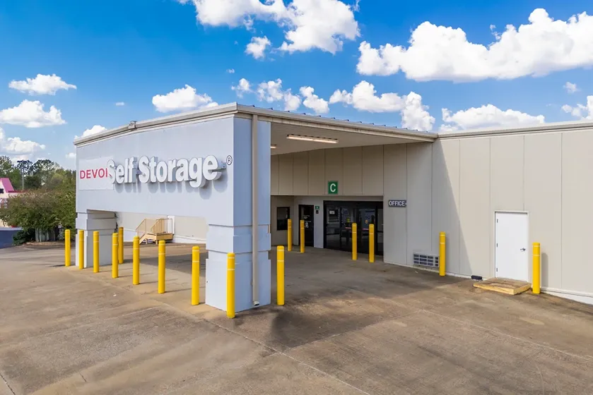 Covered drive-through loading area for indoor storage access with protective bollards