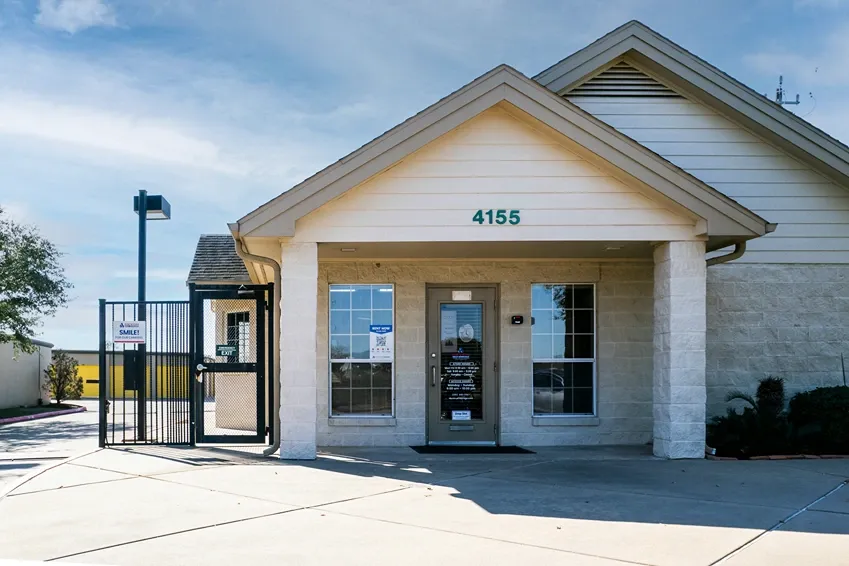 Storage facility in Pasadena, Texas. White building with stone walls.. Devon Self Storage Fairway Plaza