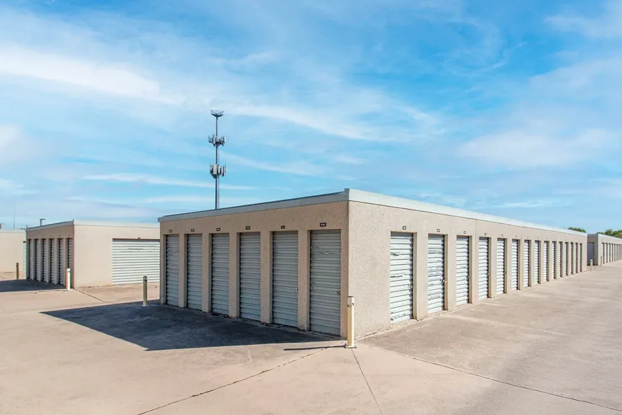 Drive-up storage units with roll-up doors and wide concrete access lanes