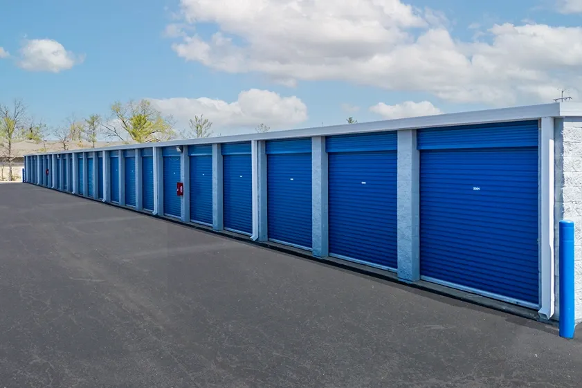 Drive-up storage units with roll-up doors and wide concrete access lanes