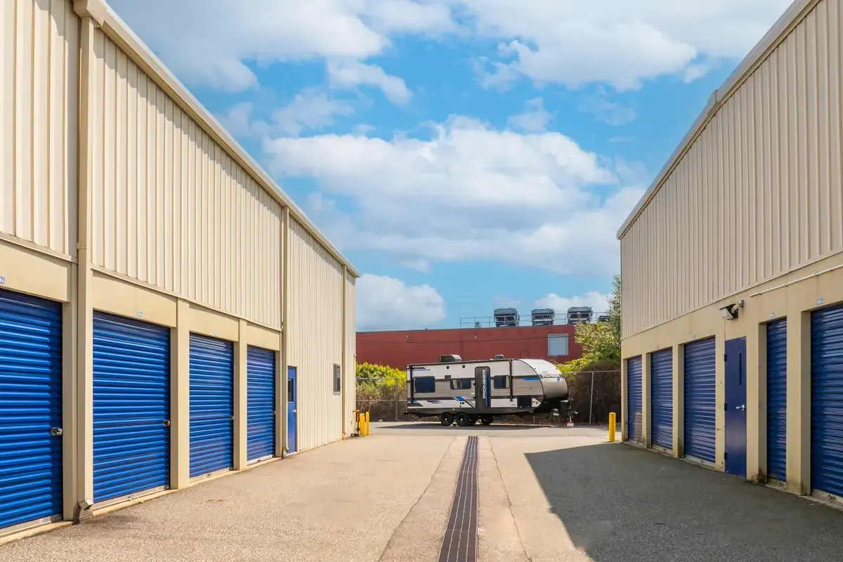 Drive-up storage units with wide access lane and parked trailer at Devon Self Storage facility