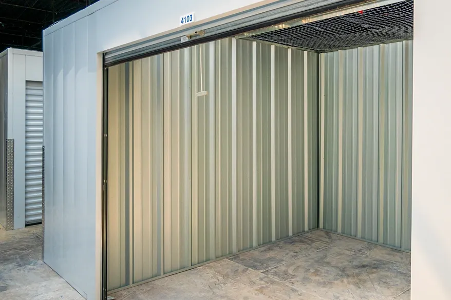 Empty indoor storage unit with metal walls and roll-up door for secure storage space