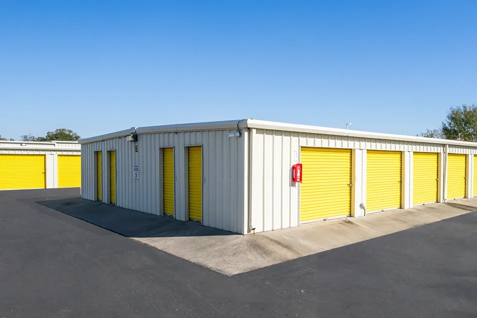 Exterior view of drive up storage units at Devon Self Storage League City. Clean, yellow doors.
