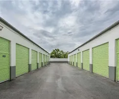 Wide driveway with drive up units and roll up doors.