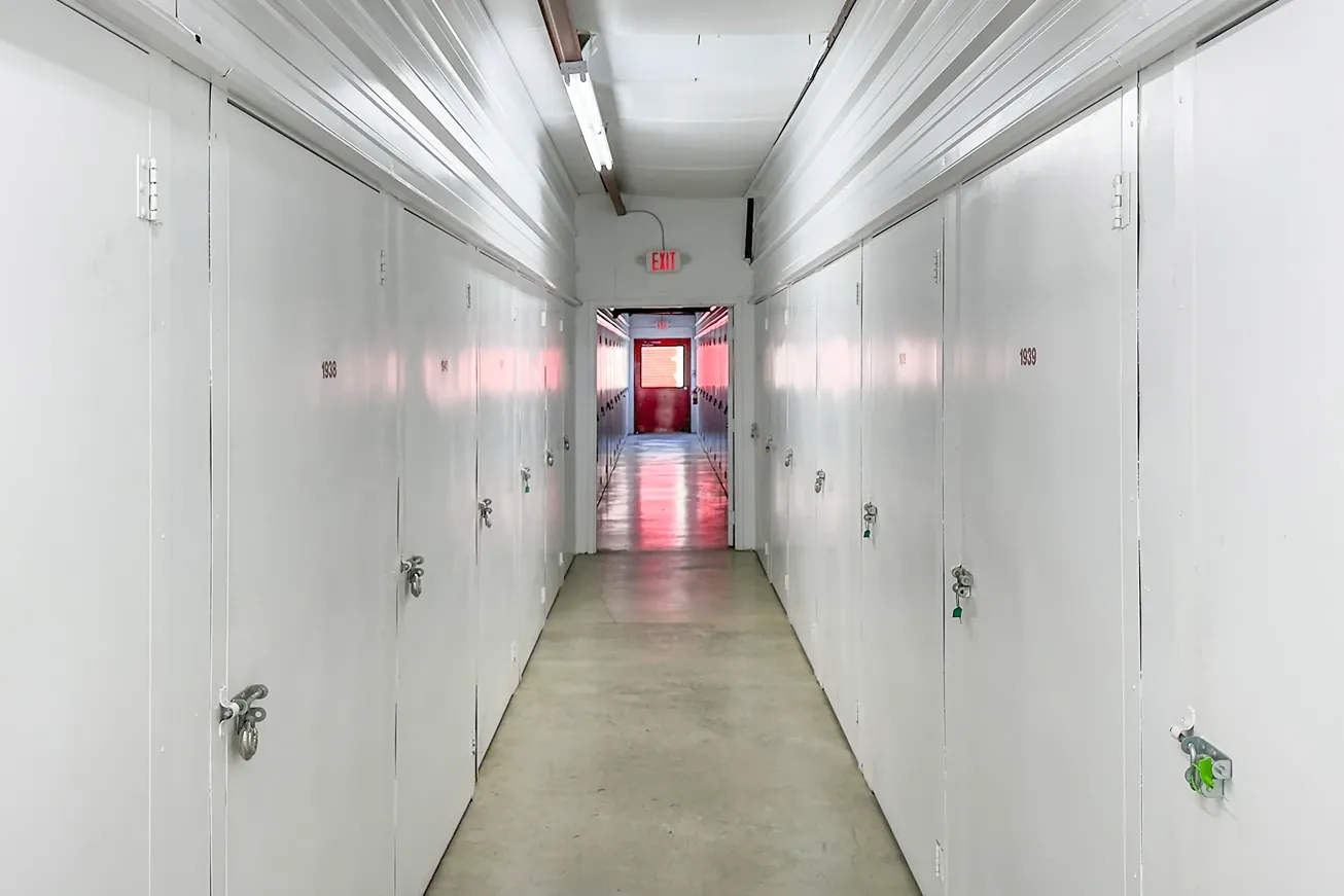 Hallway of small storage units in Hendersonville at Devon Self Storage - Main Street with white doors