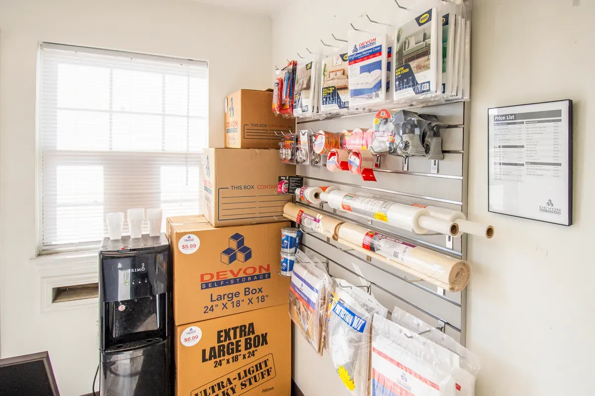 Moving and packing supplies for sale inside Devon Self Storage office including boxes, mattress covers, and packing materials