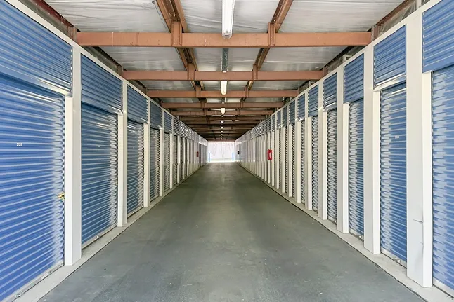 Drive-up storage units with roll-up doors and wide concrete access lanes