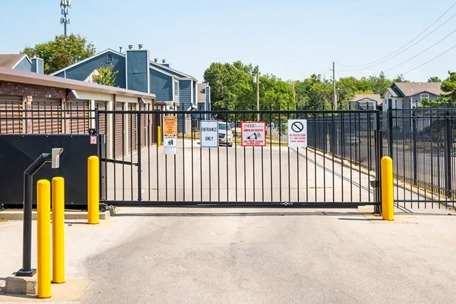Secure gated entrance to self storage facility with keypad access and perimeter fencing