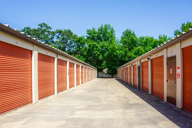 Drive-up storage units with wide access lane and orange roll-up doors