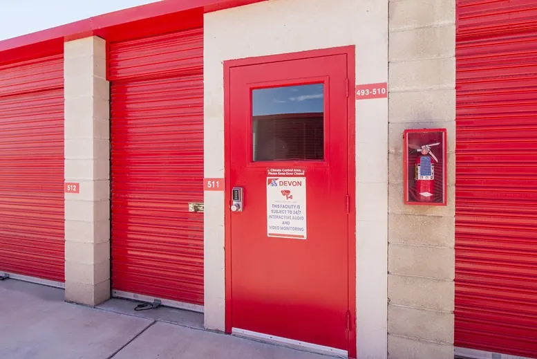 Red door entrance to storage, plus small storage unit with red doors in West Apple Valley, CA, at Devon Self Storage -...