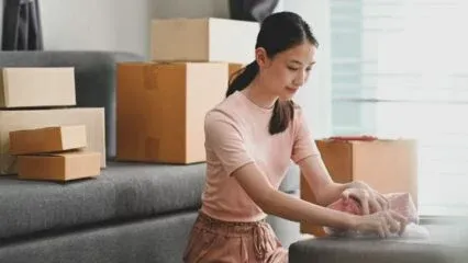 Woman packs moving boxes